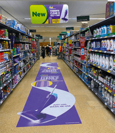 An instore photo of a Flash advert on the floor down the aisle